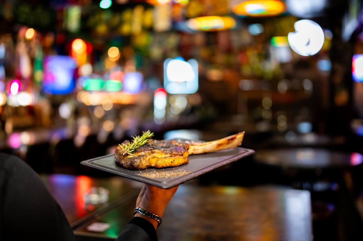 Chef serve um tomahawk flamejante na área exclusiva DOMUS Reserve
