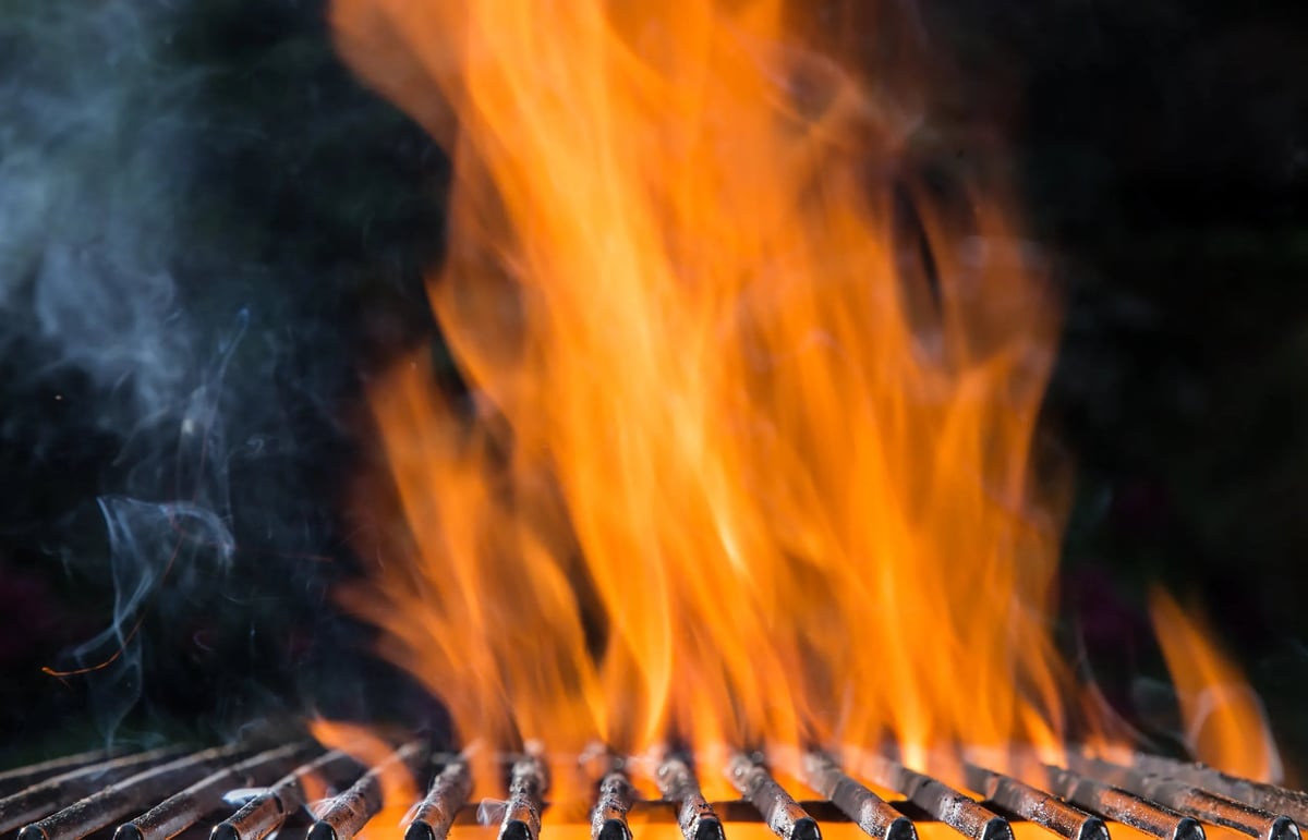 Bright orange flames rising above a metal grill grate at the DOMUS open fire